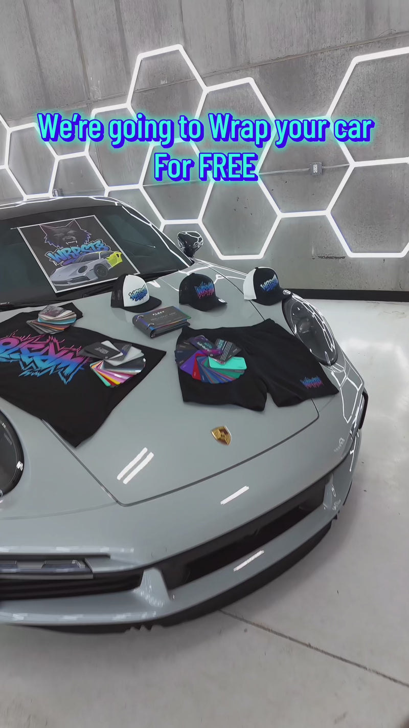 WrapState Dream Wrap Giveaway video showing Porsche sports car with custom merch including hats and shirts displayed on the hood, promoting free custom car wrap contest.